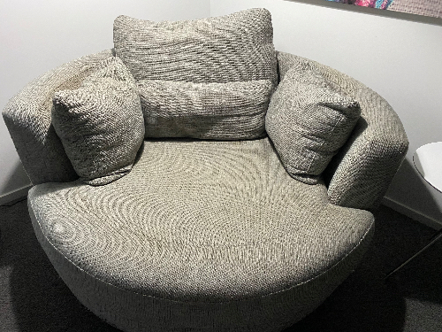Circular, textured lounge chair with multiple cushions.