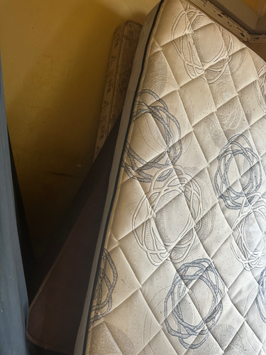 Two stacked mattresses with a patterned cover.