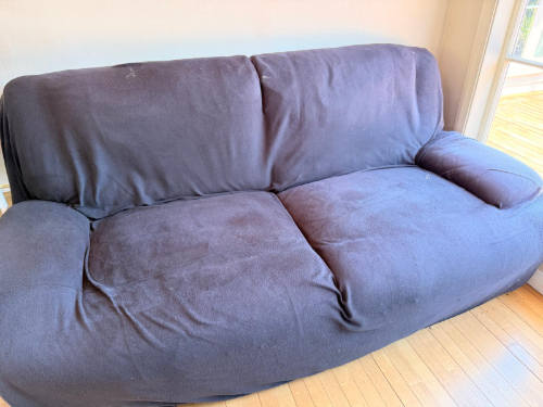 Dark fabric couch with a large, plush design.