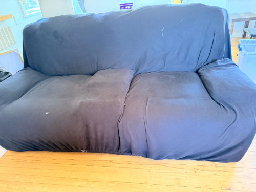 Black sofa with a soft fabric cover.