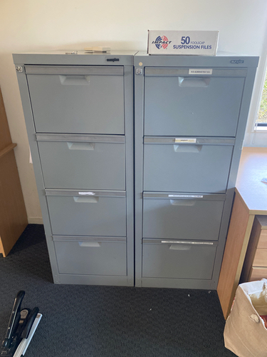 Two gray filing cabinets with six drawers each and a box labeled "50 pockets SUSPENSION FILES" on top.