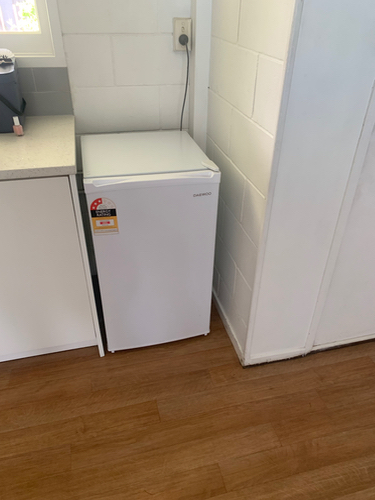 Compact white refrigerator with a price tag.