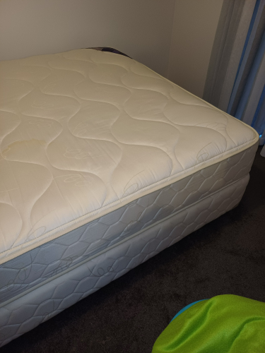 White mattress with visible stitching and slight discoloration.