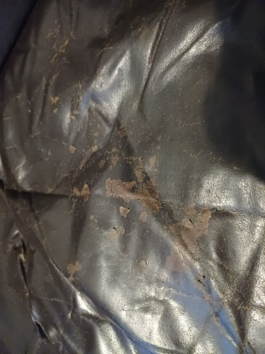 Black surface with irregular patches and stains.