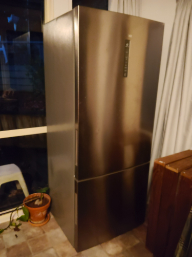 Stainless steel refrigerator with digital control panel.