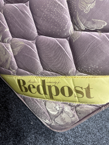 Purple quilted mattress with "Bedpost" label.