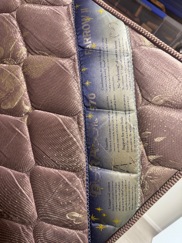 Quilted fabric with floral pattern and a care instructions tag.