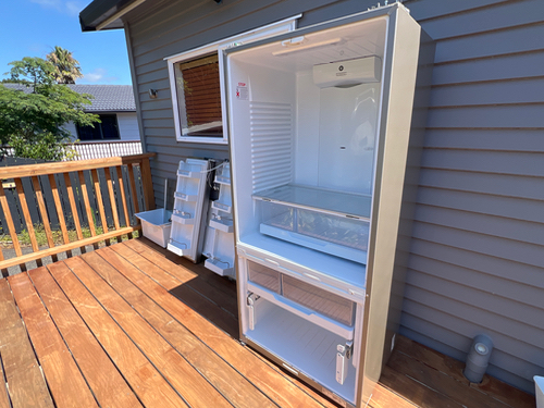 Refrigerator with open door and drawers, two storage racks.