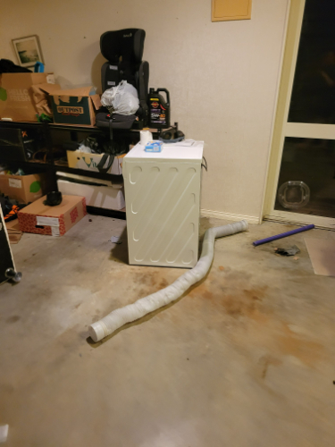 Washing machine, flexible drain hose, office chair, cardboard boxes.