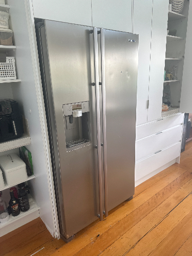 Stainless steel side-by-side refrigerator with ice and water dispenser.