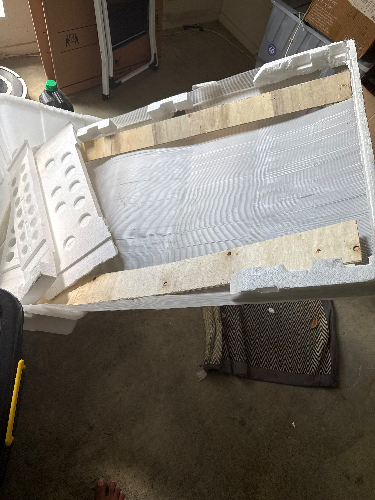 White foam container with wooden slats inside, partially open.