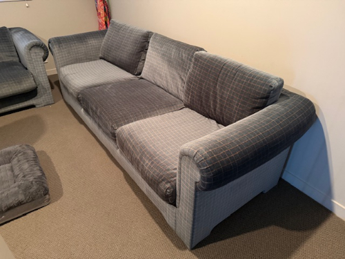 Gray and blue plaid three-seater sofa with armrests.
