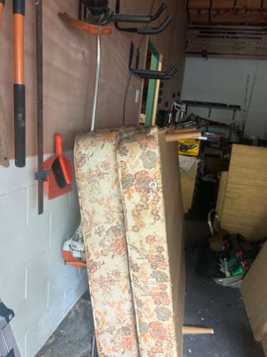 Stacked floral-patterned mattresses and various tools.