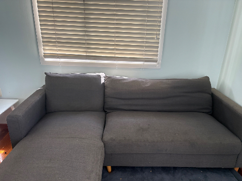 Gray sectional sofa with wooden legs.