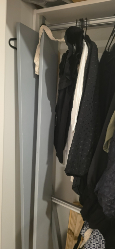 Gray hanging panel and various black and white clothing items.
