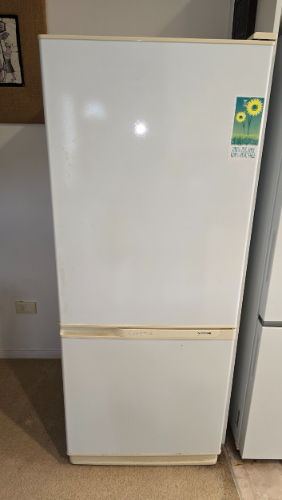 White refrigerator with a sunflower sticker.