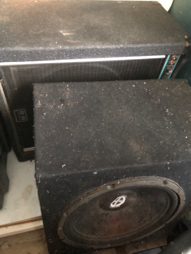 Two dusty speaker boxes, one above the other.