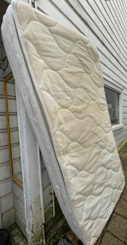 Mattress leaning against a wall.