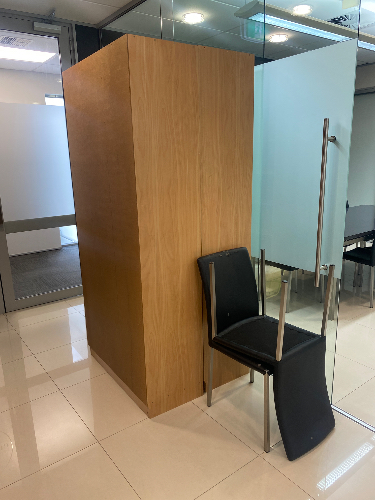 Wooden partition and a black chair leaning against it.