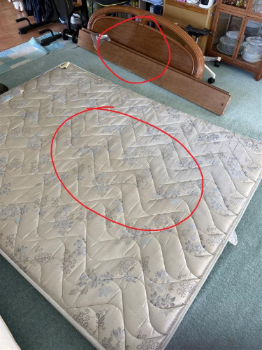 Mattress, wooden bed frame headboard.