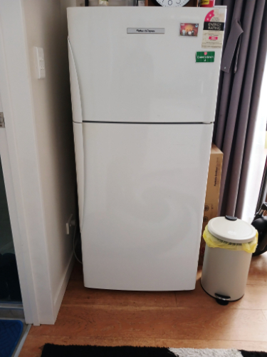 White refrigerator and trash can with yellow lid.