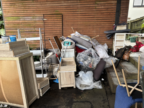 Pile of furniture, bags of waste, and assorted household items.