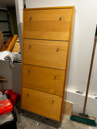Tall wooden chest of drawers with four compartments and silver handles.