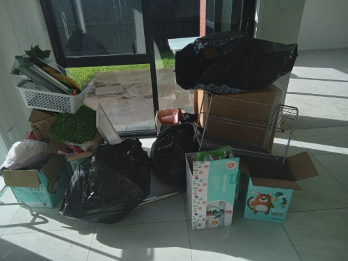 Boxes, trash bags, a wire shelving unit, and decorative items.
