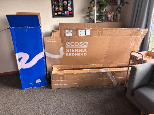 Cardboard boxes, including a blue Ecosa Sierra Bedhead box and several flattened cardboard pieces.