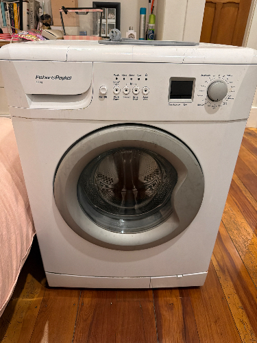 Front-loading washing machine with control panel and transparent door.