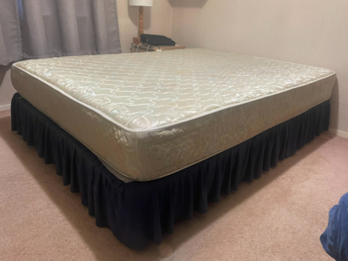 Mattress with a decorative bed skirt.
