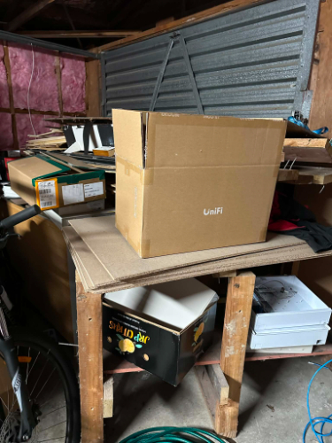 Cardboard box labeled "UniFi," various other boxes, bicycle.
