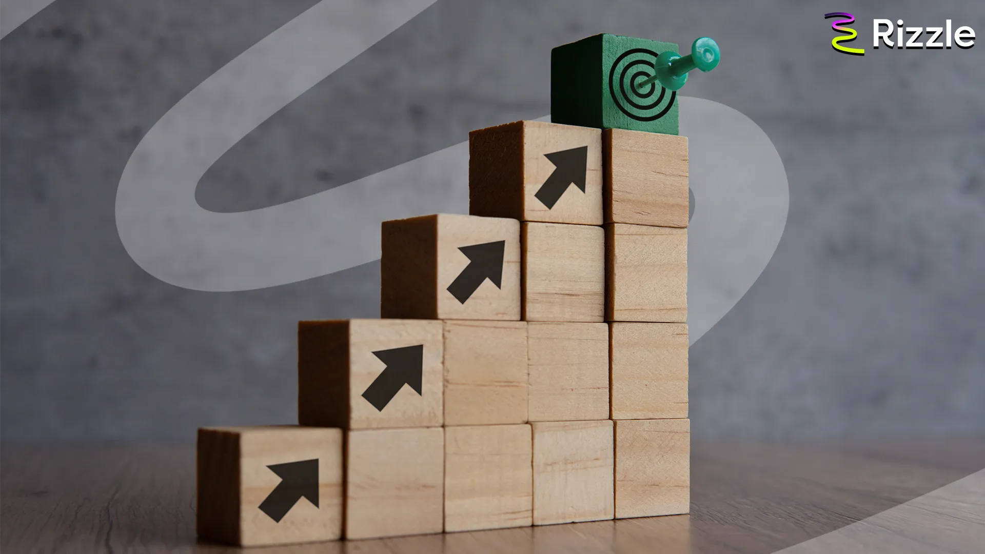 Wooden blocks stacked in a staircase, with arrows pointing upwards and a target on top, symbolizing growth and goal achievement.