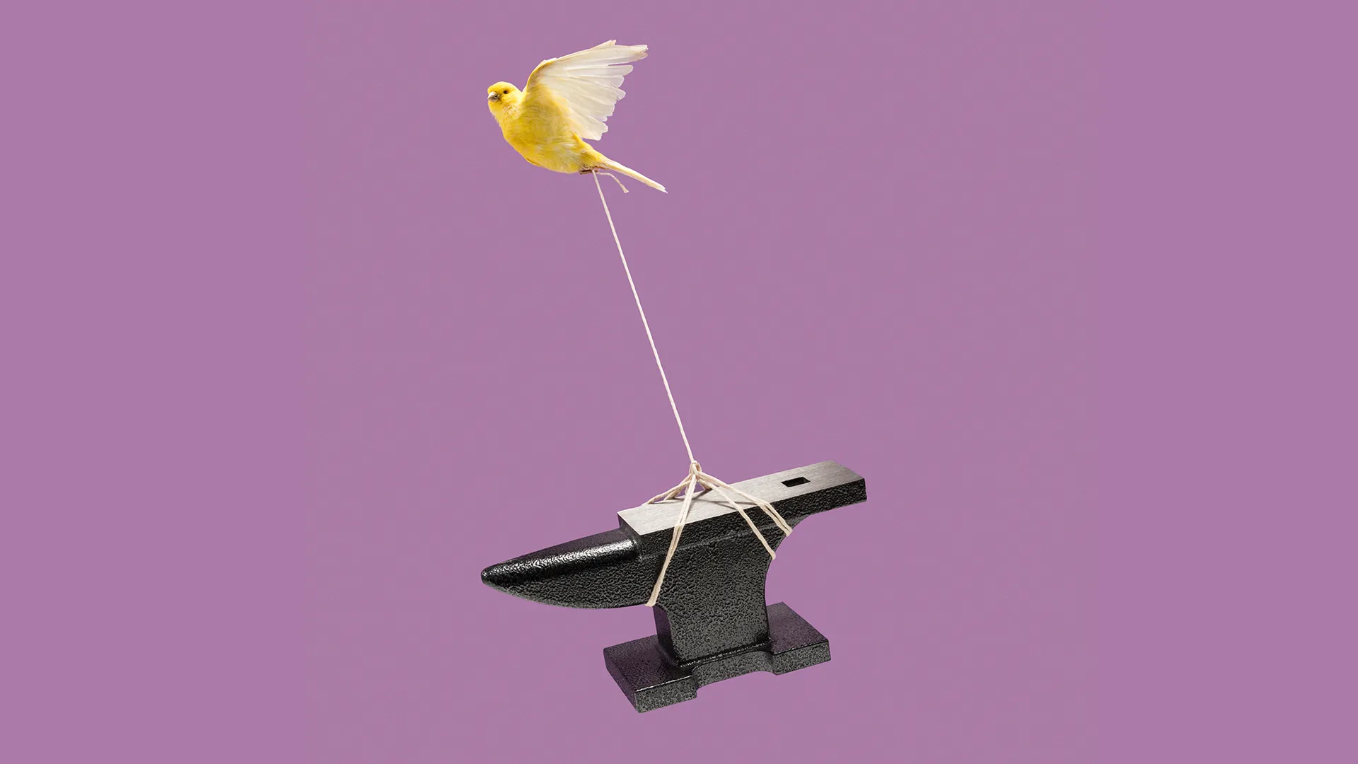 A small bird flying while tethered to an anvil, symbolizing the challenge of creating impactful thumbnails.