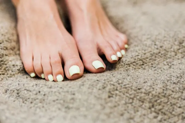 Person removing shoes after walking, highlighting the importance of foot hygiene.