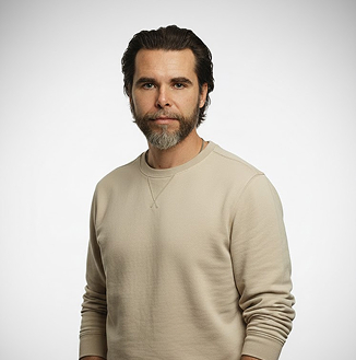Porträt von Marcel Morach vor grauem Studiohintergrund, im beigen Pullover.