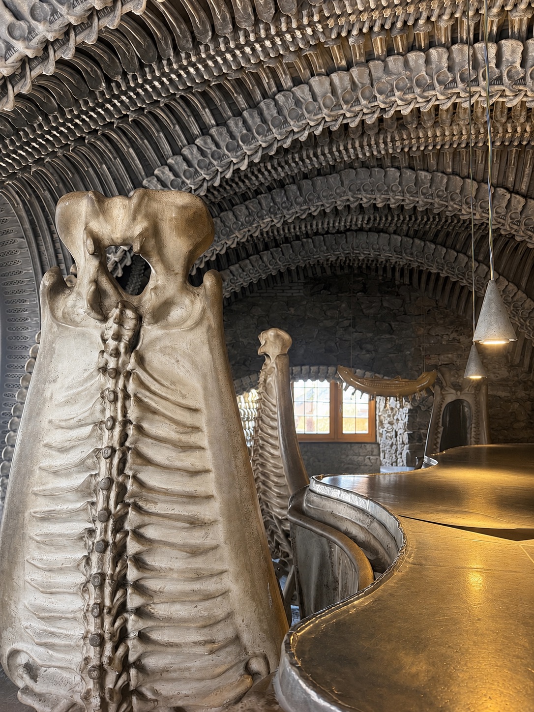 Innenraum einer Bar mit biomechanischer, skelettartiger Architektur aus geschwungenen Wirbel-Formen.