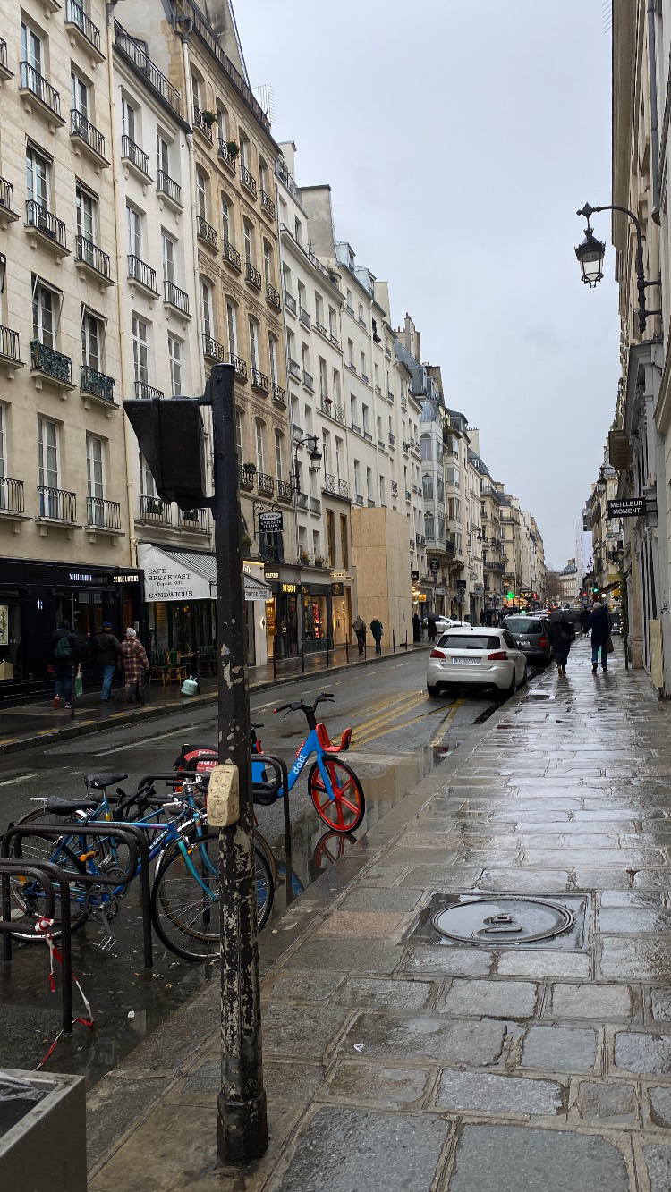 Regennasse Strasse in einer europäischen Altstadt mit Fahrrädern und historischen Fassaden.