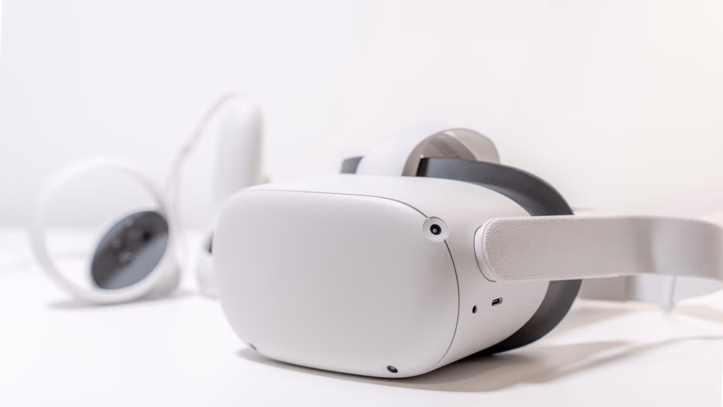 Eine VR-Brille mit Controllern auf weissem Hintergrund.