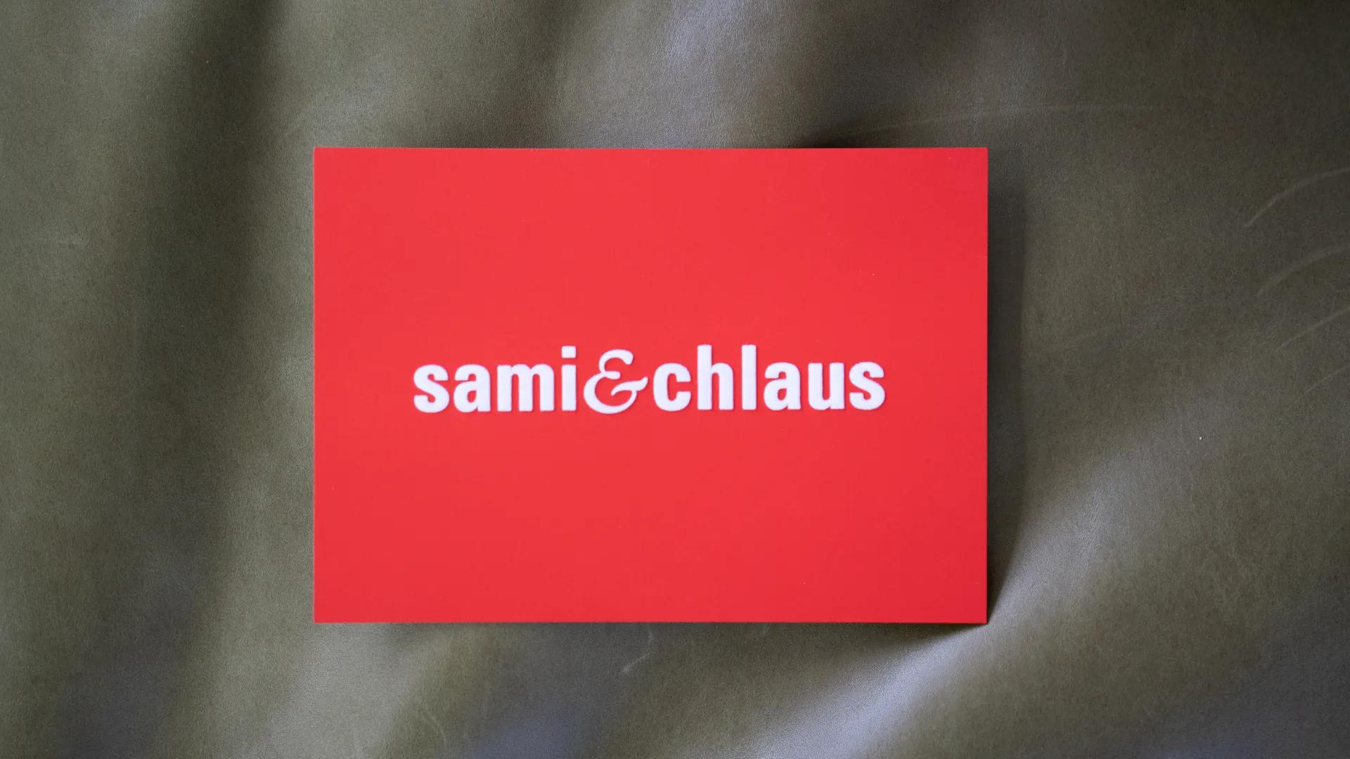 Rote Weihnachtskarte für kunz&huber mit dem Schriftzug «sami&chlaus» in weisser Schrift