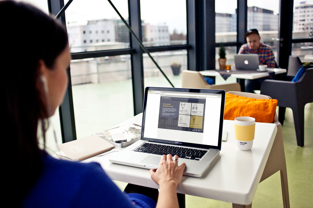 A mockup of the diversity course on a laptop, observed by a user sitting in a cafe.