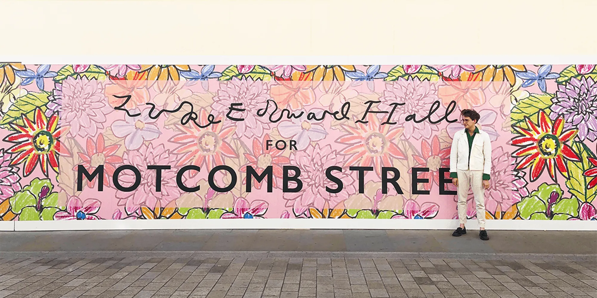 Colorful floral mural by Luke Edward Hall for Motcomb Street with a man in white standing on the right.