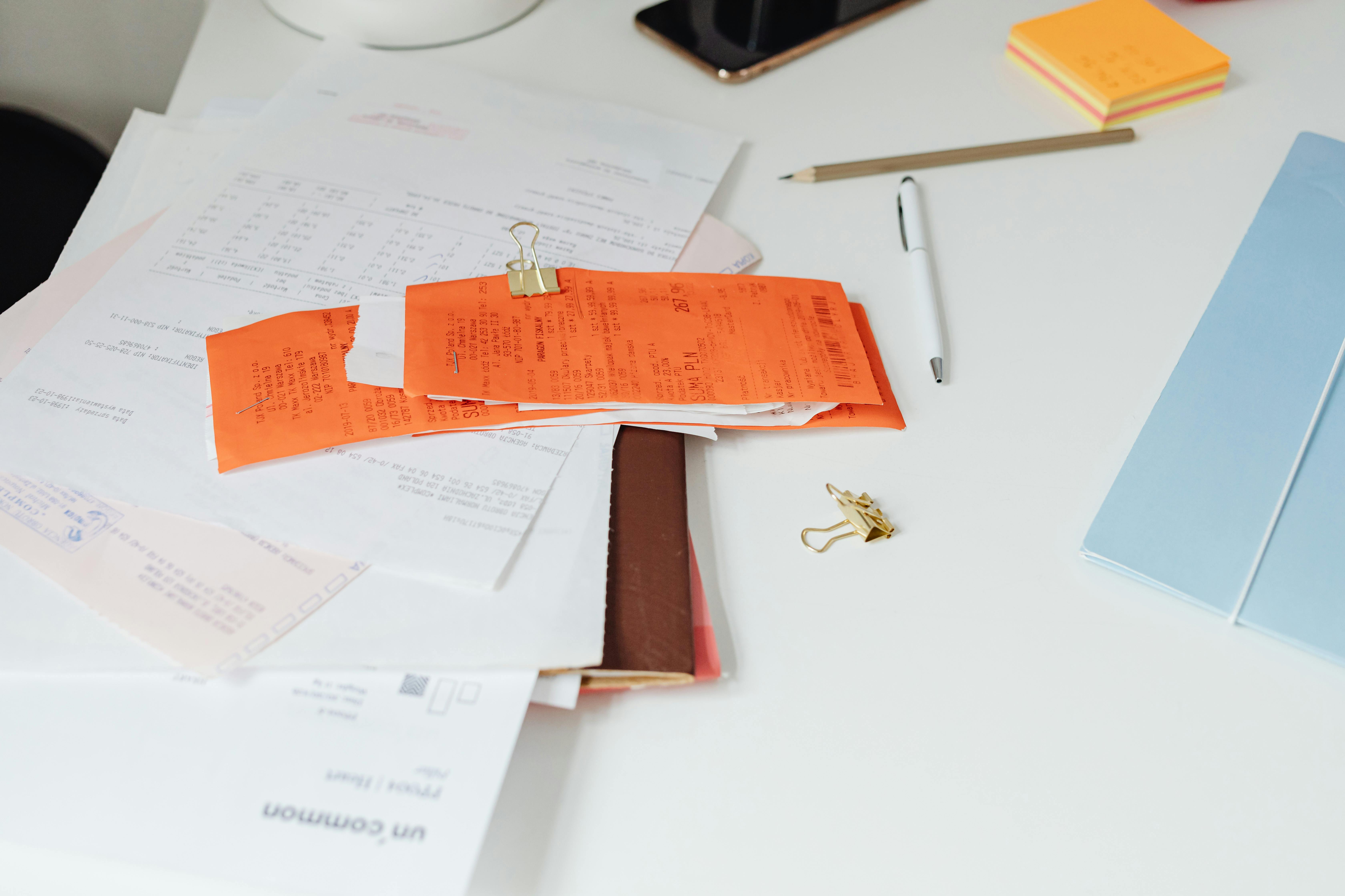 Close-up of a tidy desk with receipts, documents, and office stationery for business organization.