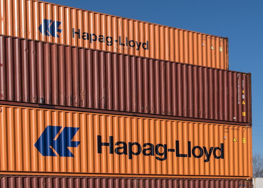 Colorful Hapag-Lloyd shipping containers stacked at a container terminal in Hamburg.