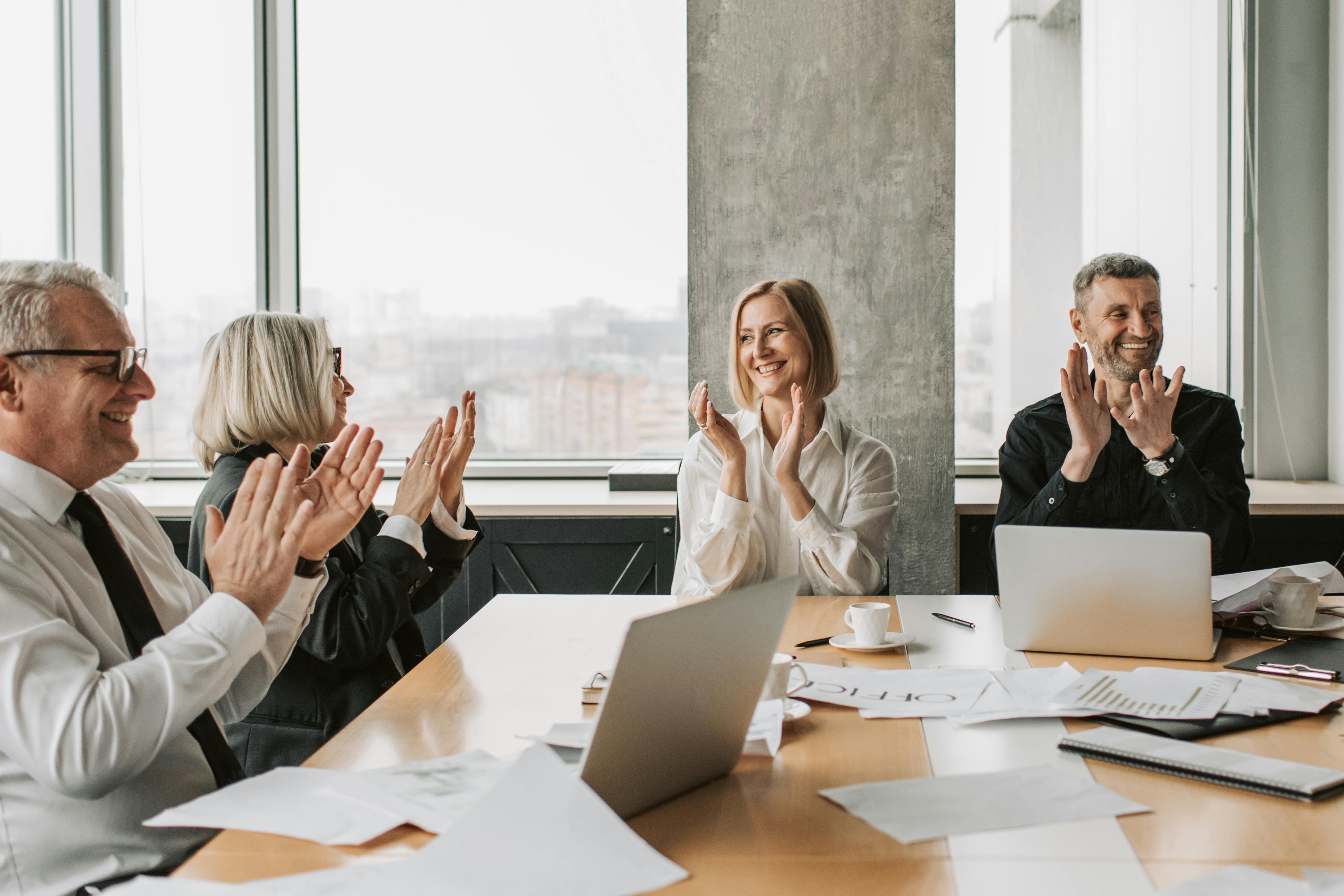 Business professionals clapping in a conference room, creating a lively and positive work environment.