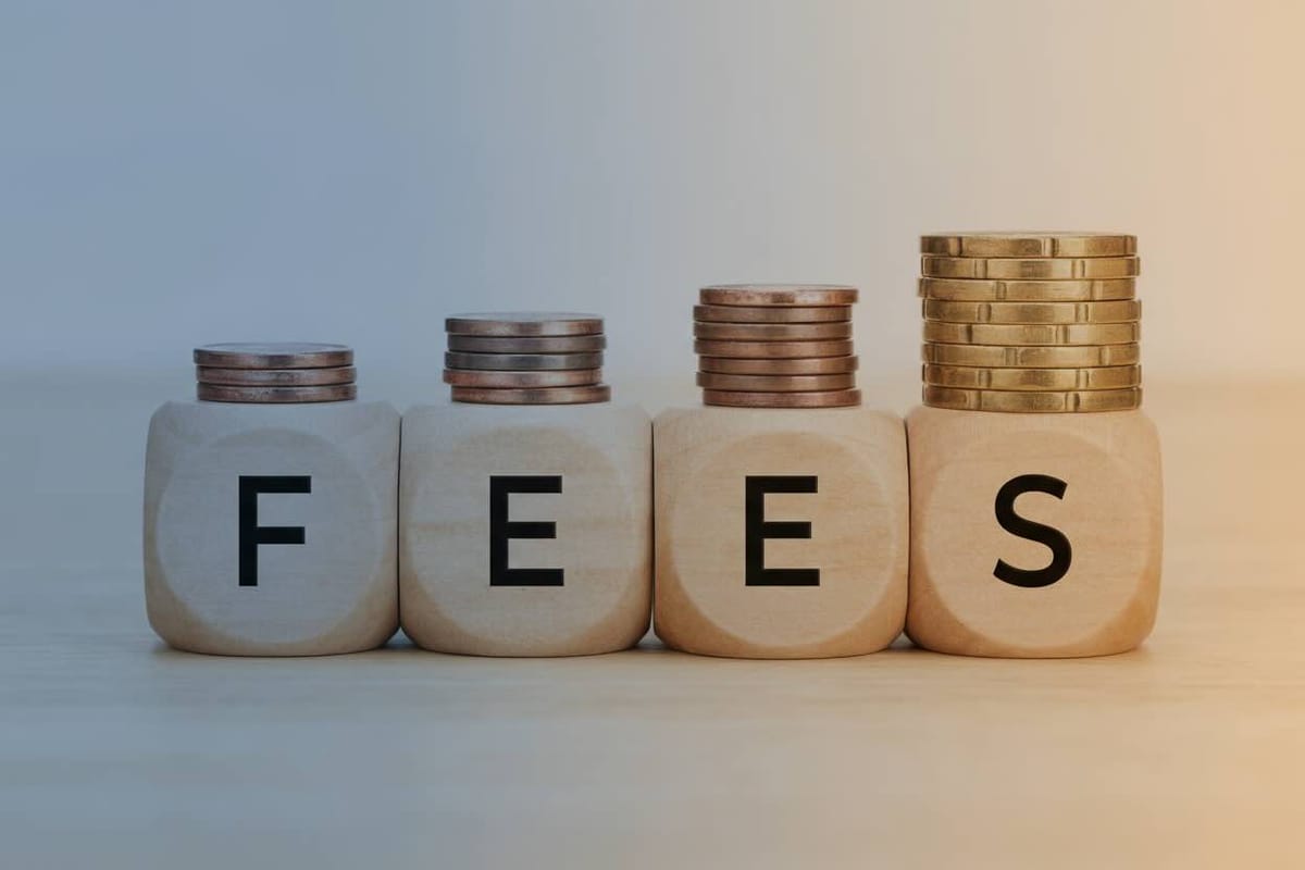 Wooden Blocks Spelling 'FEES' with Stacked Coins Increasing in Height from Left to Right on a Light Background