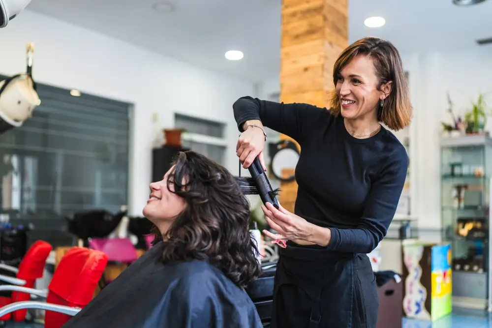 hair stylist curling customer's hair