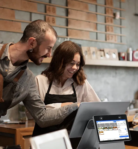 Cafe staff using the Payflo POS terminal at the counter