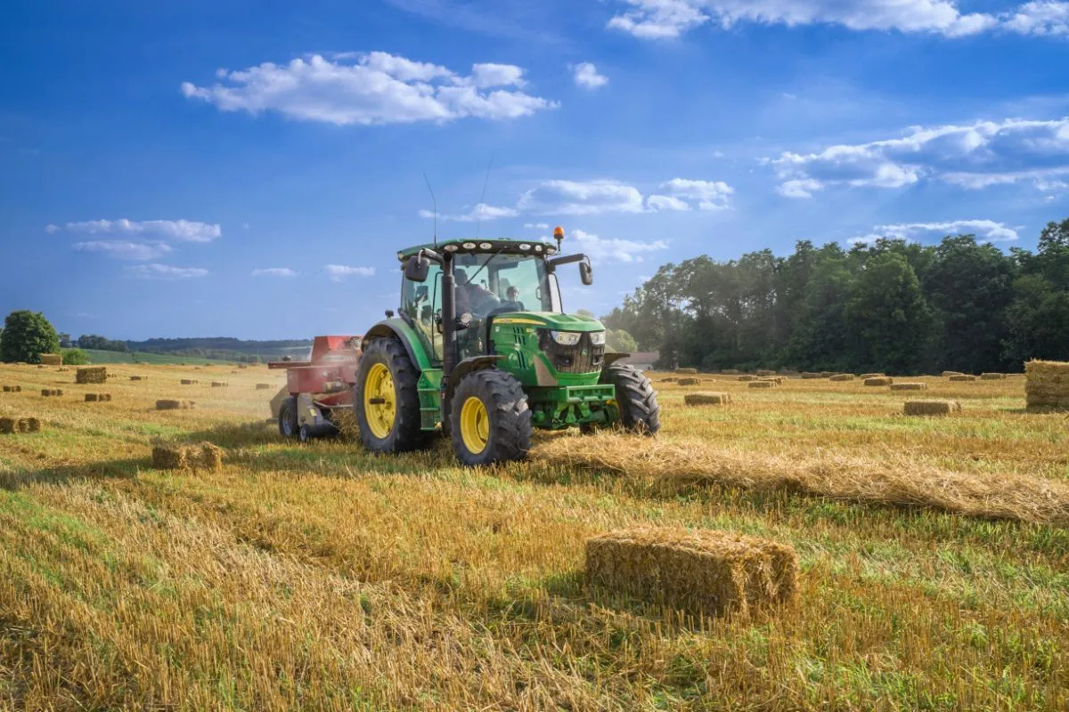 Un agriculteur dans son tracteur dans un champ. Cet image représente les professionnels qui peuvent être intéressé par les formations Permaterra.