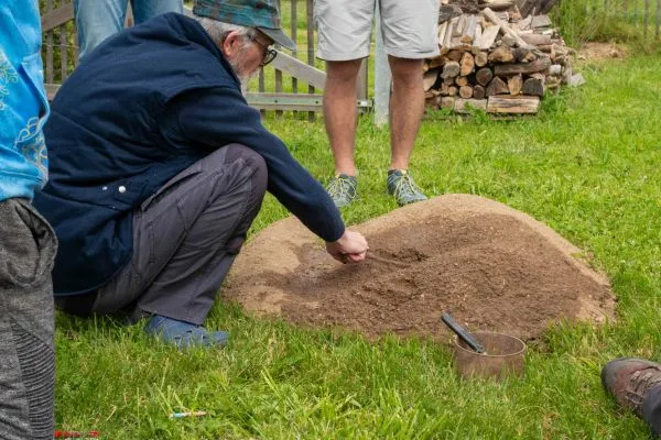 Photo du formateur qui verse de l'eau sur de la terre durant la formation gestion de l'eau et hydrologie régénérative.